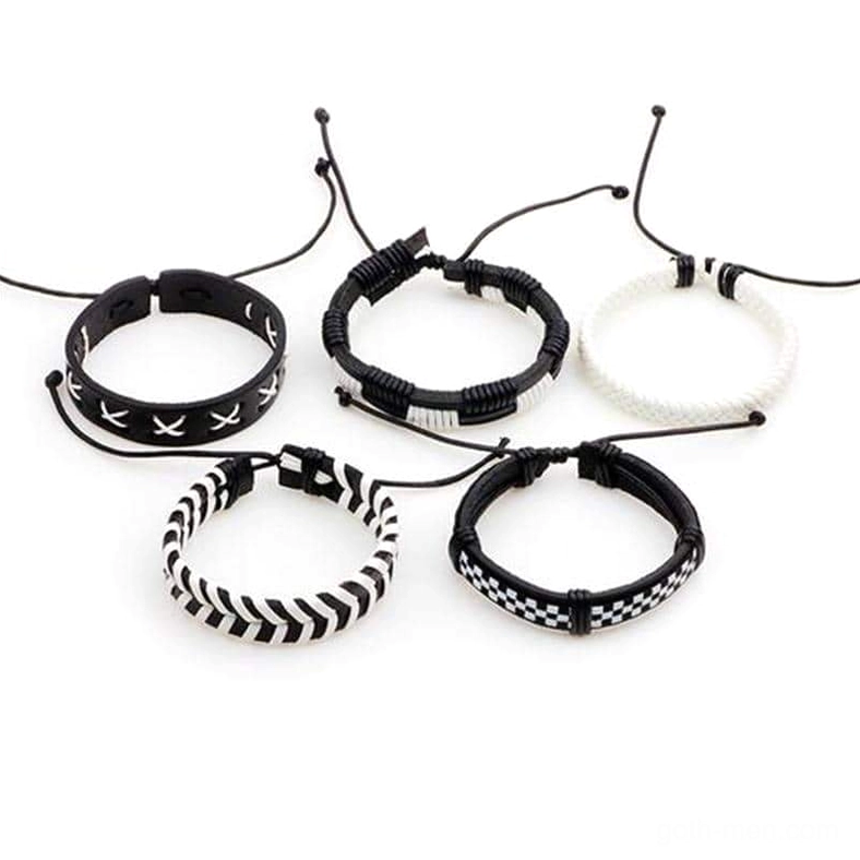Five-piece adjustable woven gothic bracelet collection in black, white, and cream tones - top-down flat lay