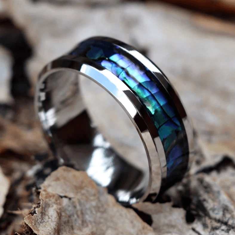 Low angle side view of abalone inlay gothic ring with shiny polished metal trim