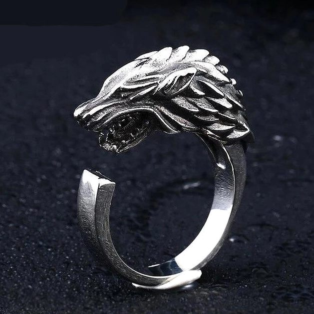 Adjustable open wrap wolf head ring with side carving, antique silver band, dark textured background showing asymmetrical design