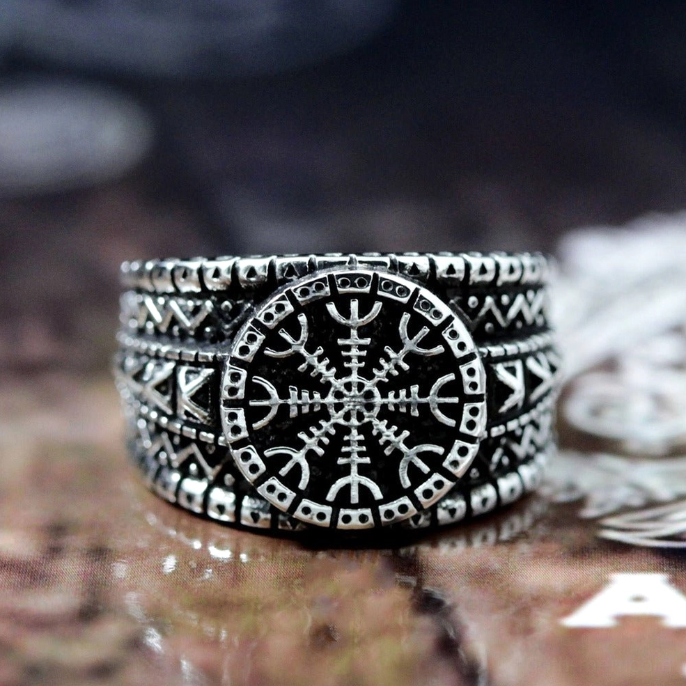 Aegishjalmur rune ring displayed on wooden table - engraved tribal and protection patterns
