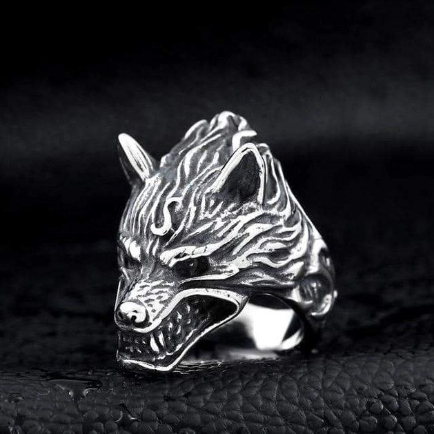Aggressive open-mouth wolf head ring with detailed fur texture, antique silver finish, oblique front view on leather background