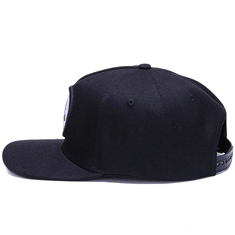 Alternative goth snapback cap showcasing structured flat brim and embroidered skull motif from side angle on white background