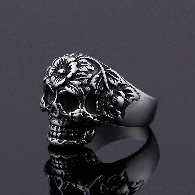 Dark silver gothic skull ring three-quarter view, detailed flower decorations, aged vintage texture, alternative jewelry
