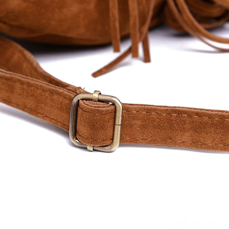 Close-up of metal adjustment buckle and matching suede fringe on gothic tassel backpack strap