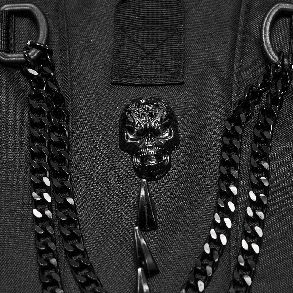 Tactical backpack hardware close-up featuring metal chains, skull ornament, D-rings, and heavy-duty nylon canvas construction