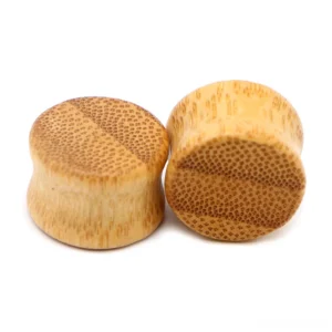 Solid bamboo ear stretcher gauges in warm honey tone showing natural wood spotting and organic texture detail