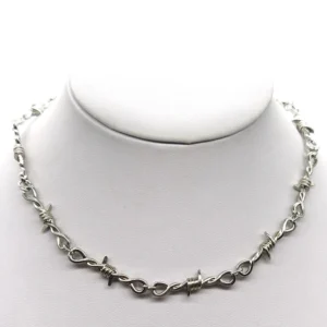 Silver barbed wire gothic choker necklace displayed on white mannequin neck, front close-up view showing detailed thorn chain links and industrial design aesthetic