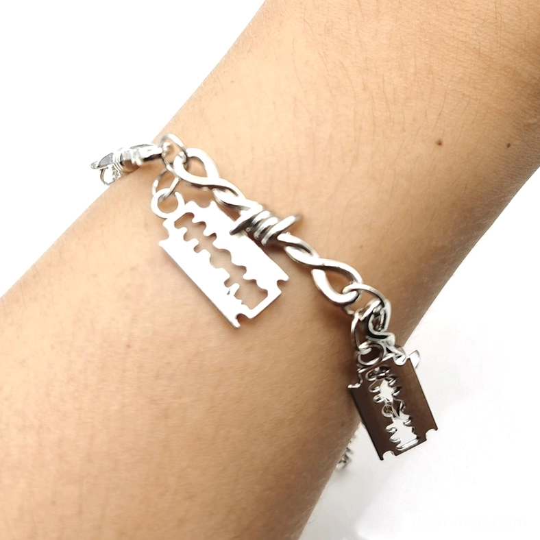 Barbed wire razor blade gothic bracelet worn on wrist, side close-up detail showing two razor pendants on twisted chain