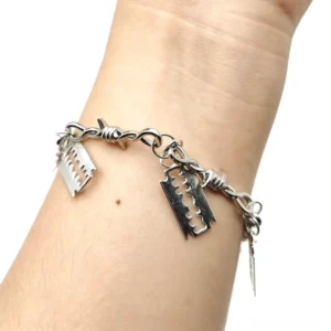 Barbed wire razor blade gothic bracelet worn on wrist, side close-up view showing twisted chain with four razor pendants in silver-tone zinc alloy
