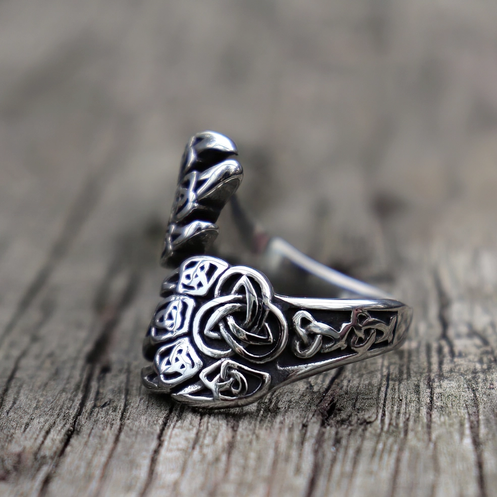 Close-up detail of Celtic knot bear claw ring showing intricate vintage engraved patterns and stainless steel craftsmanship on wooden background