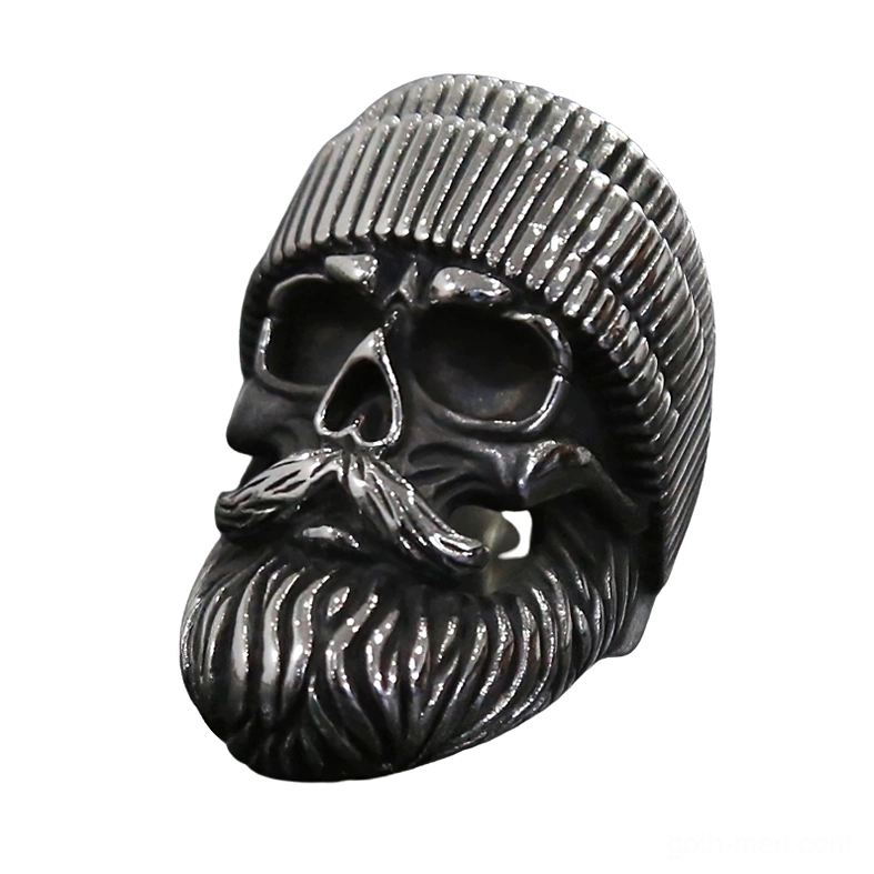 Bearded skull biker ring with detailed facial hair and ribbed beanie hat, left front three-quarter view on white background showing dark stainless steel gothic finish