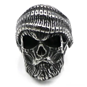 Front view of bearded skull ring wearing knit beanie, hollow eye sockets and aged metal finish, gothic statement jewelry piece