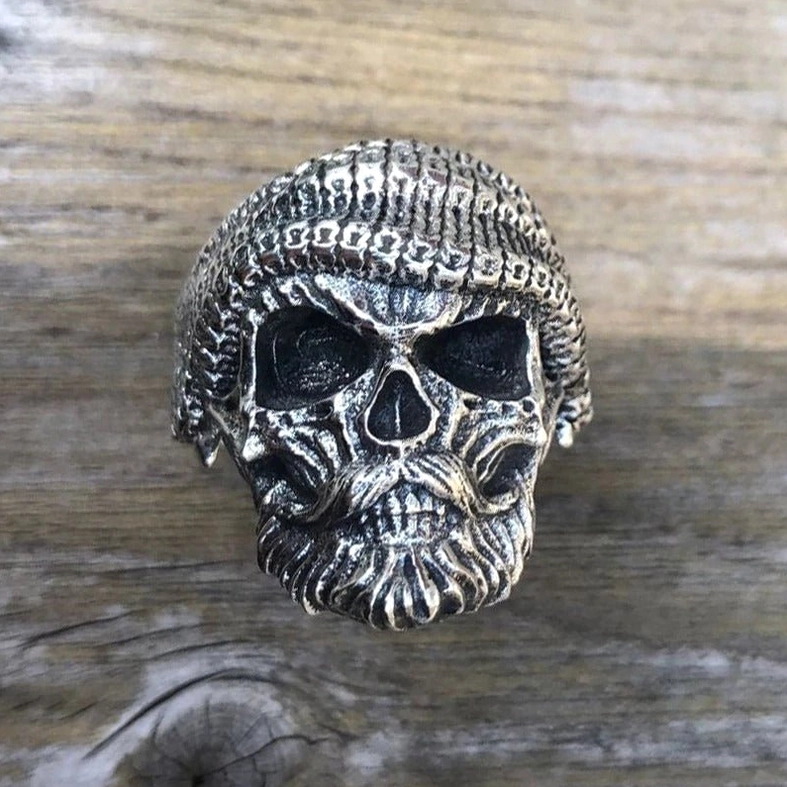 Bearded skull ring on wooden surface – full carved gothic skull with beard detail in antiqued silver