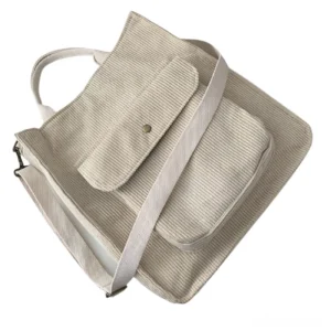 Beige corduroy gothic handbag with adjustable shoulder strap, side angle view showcasing ribbed texture detail