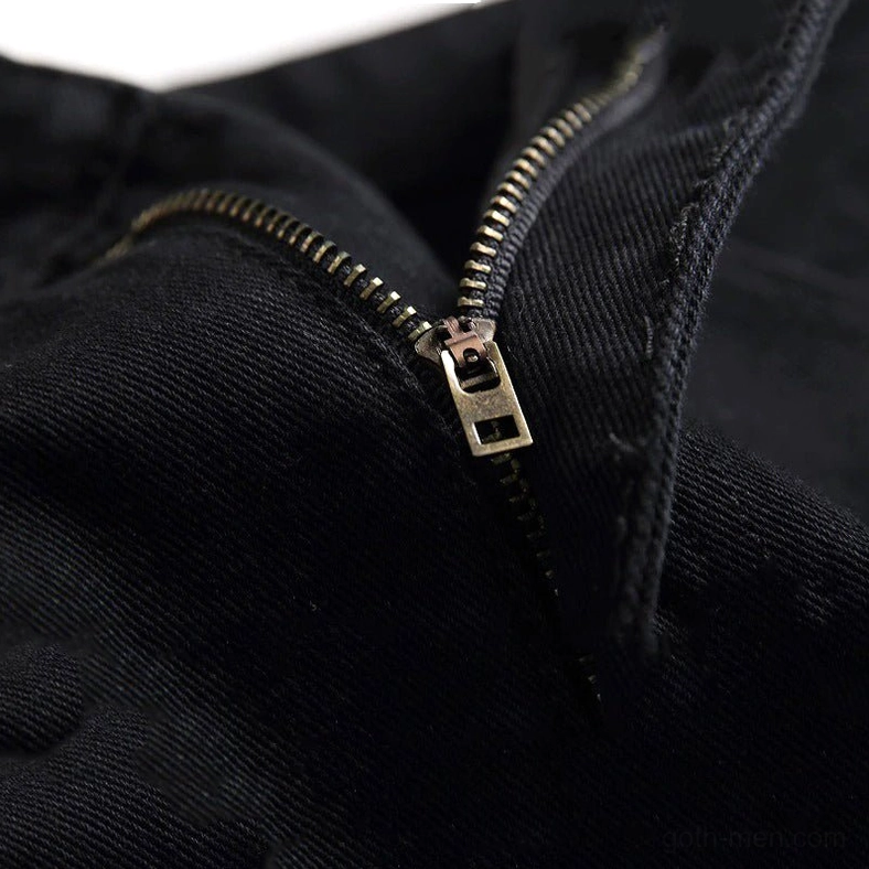 Gold-toned metal zipper fly detail on black gothic biker denim jeans macro close-up shot