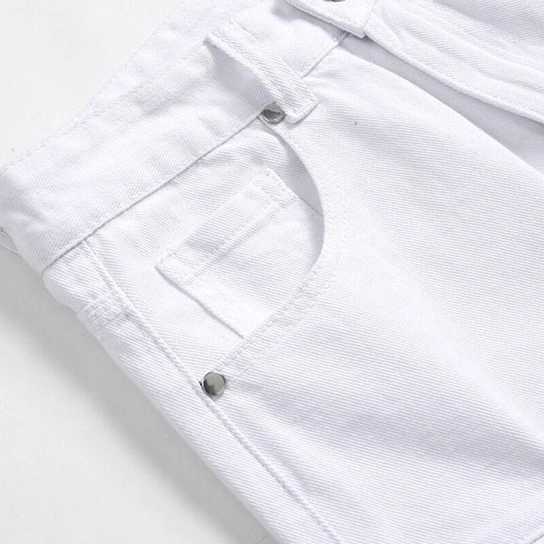 Close-up detail of gothic biker jeans waist featuring metal button, coin pocket, and white denim construction