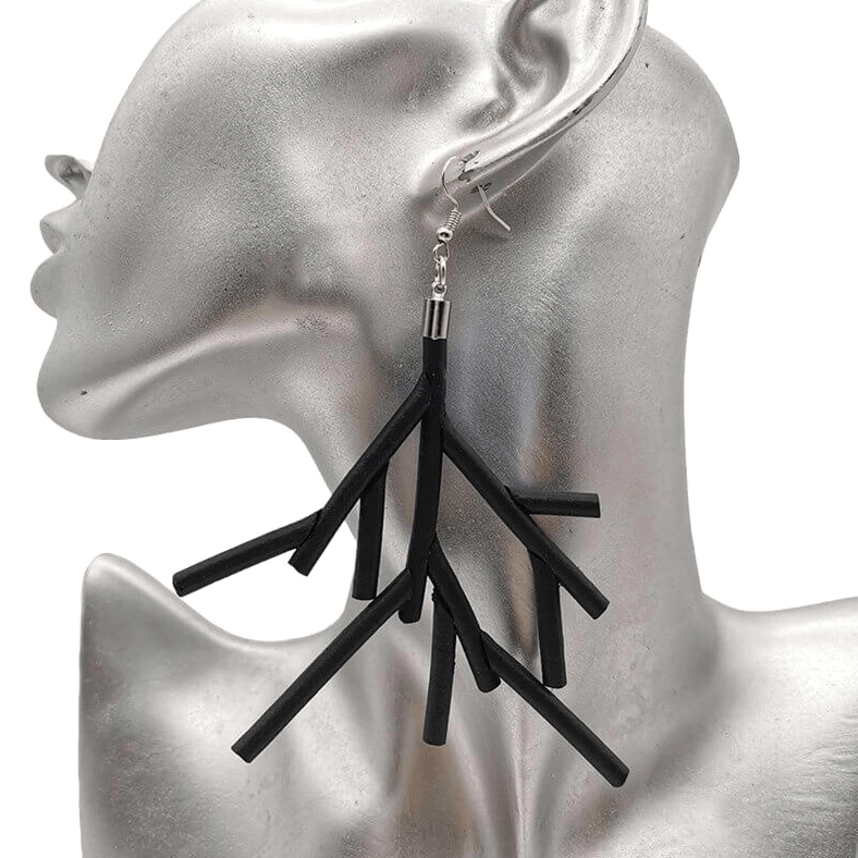 Black branch dangle earrings on silver ear mannequin, close-up left side view showing matte black silicone tree branch design with silver-plated aluminum hook
