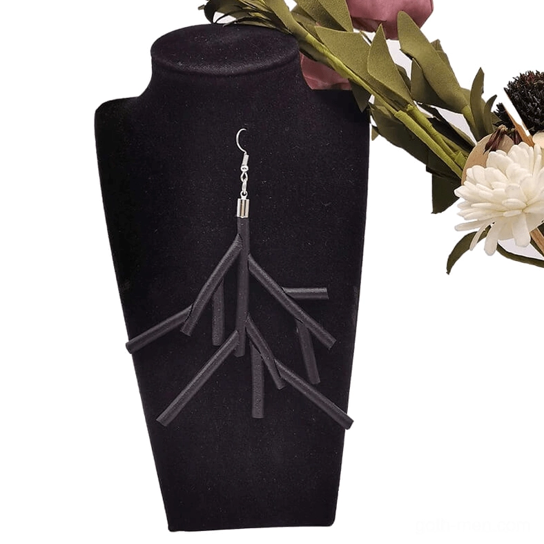 Black branch dangle earrings displayed on black velvet jewelry stand with floral studio backdrop, gothic statement jewelry presentation