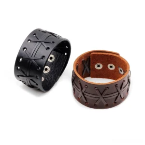Black and brown leather wide cuff bracelets displayed flat lay, showing cross-stitched exterior and metal snap fasteners