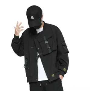 Black cargo bomber jacket with multi-pocket design and strap buckles, front view on male model wearing NY baseball cap