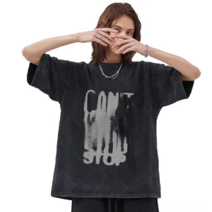 Female model in unisex black cotton graphic tee with faded letter print, full-body front shot, loose oversized fit