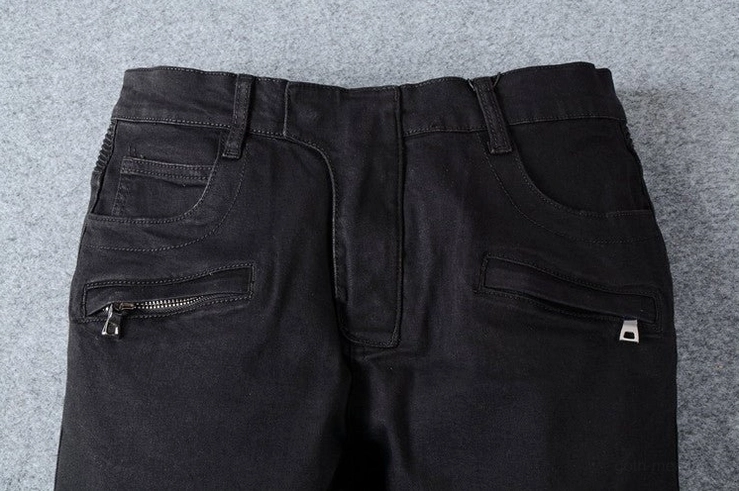 Black denim jeans waist and fly detail - metal zipper closure and side pockets close-up