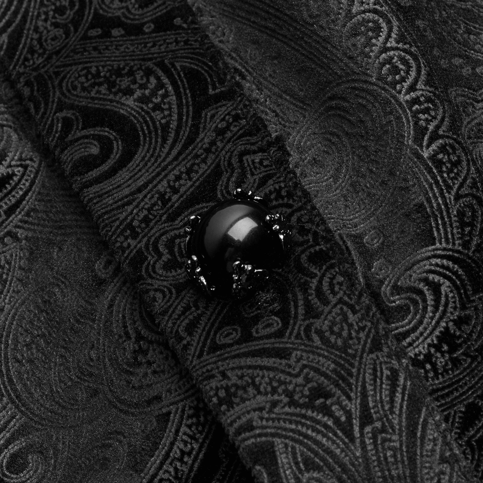 Macro detail of black gemstone button with ornamental metal claw setting and paisley jacquard fabric texture