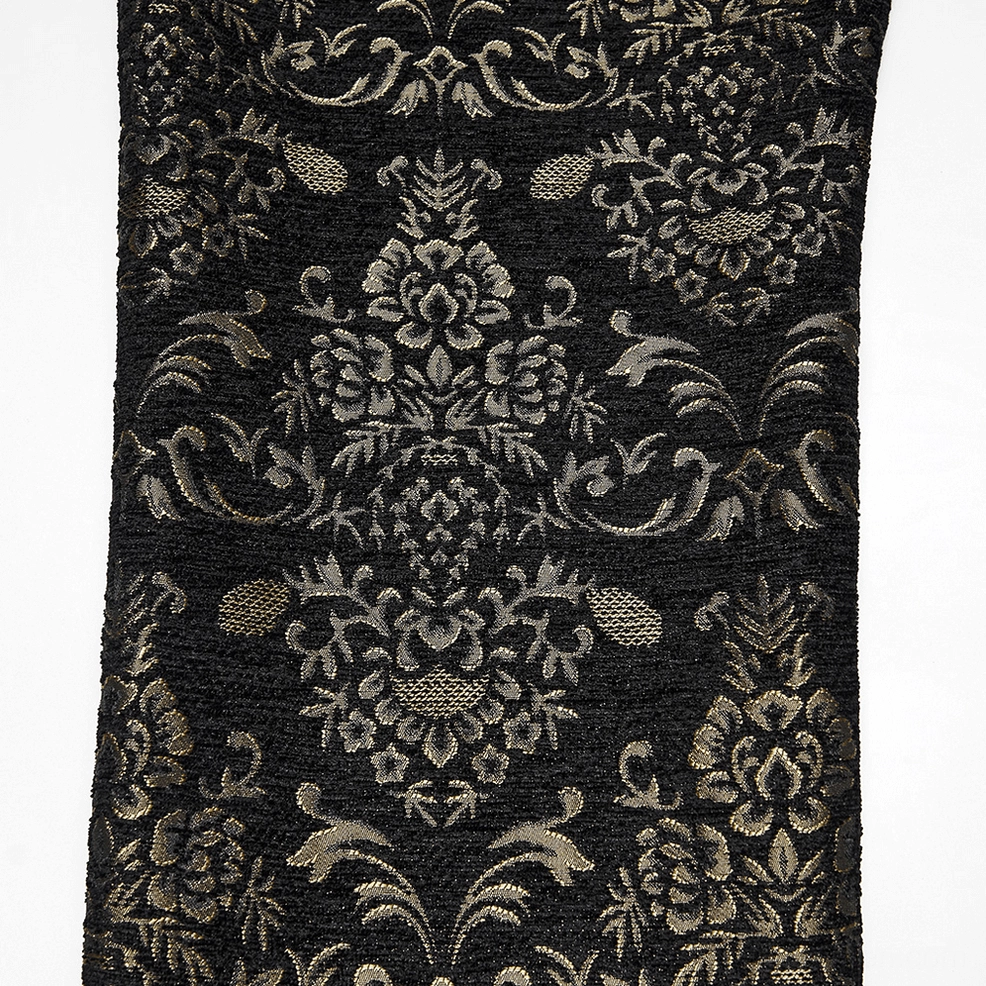 Close-up detail of front waist area on black and gold jacquard gothic pants showing sculptural velvet bat-wing yoke and central embroidery