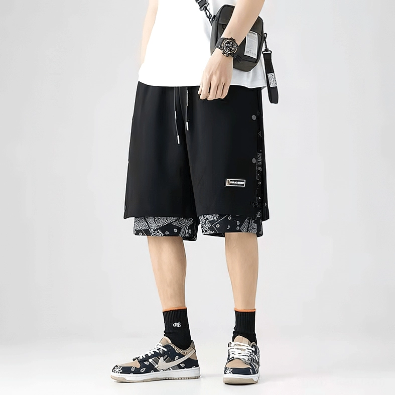Full body model wearing black gothic shorts with paisley hem, alternative streetwear styling with boots