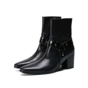 Pair of black leather pointed toe gothic ankle boots with metal harness strap and block heel, front view studio shot