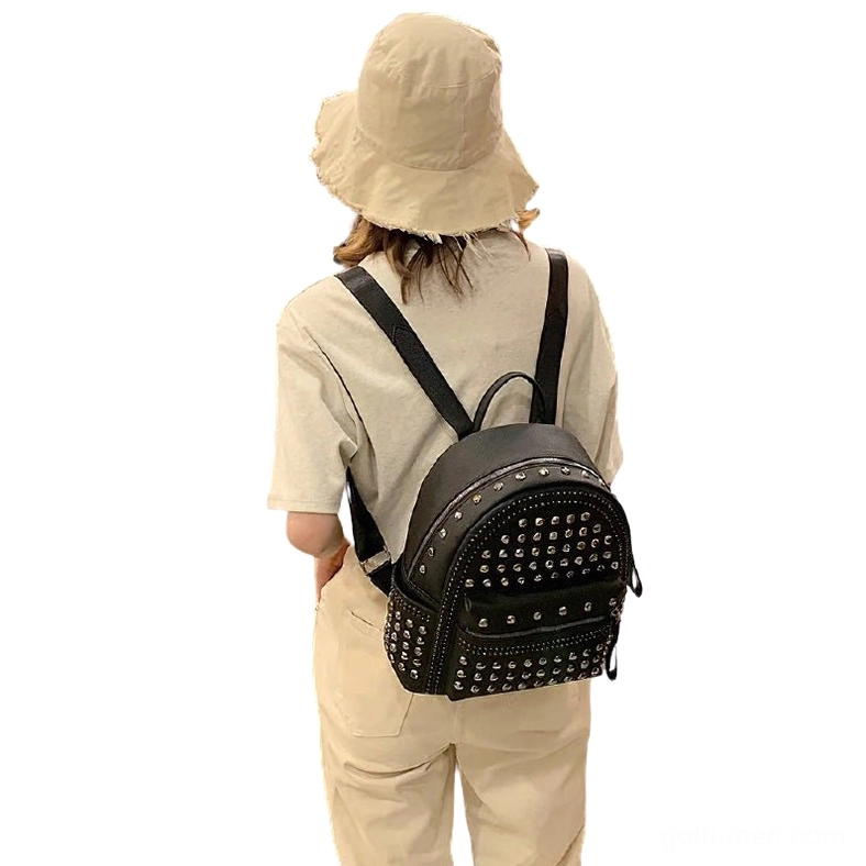 Rear view of black rivet decorated gothic backpack on model showing shoulder straps and back design