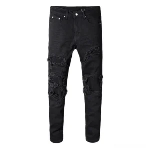 Black distressed gothic biker jeans with patchwork ripping at knees, slim fit pencil silhouette, full length front view on flat lay