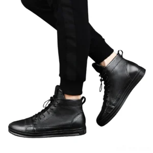 Men wearing black gothic ankle boots with lace-up system - side view with black track pants styling