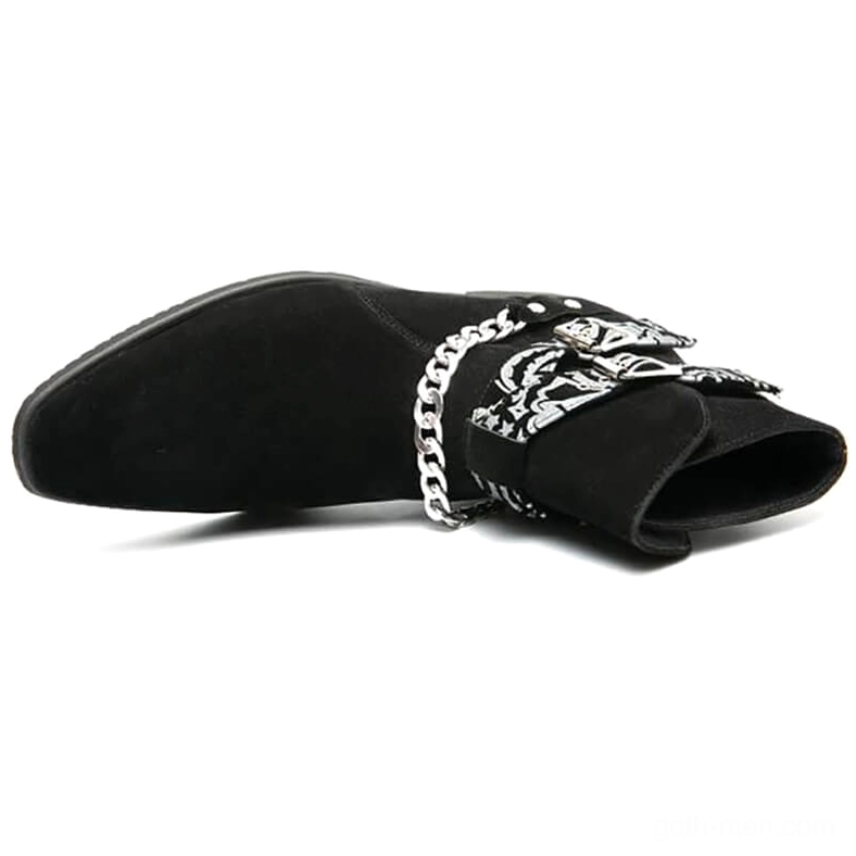 Overhead flat lay view of black gothic ankle boots with paisley buckle straps chain accents on white background