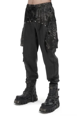 Black gothic cargo joggers with tie-dye splice and rivet hardware worn by male model, front side view