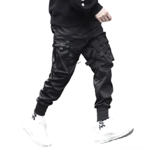 Black gothic cargo joggers with multi-pocket design worn by male model, rear side view showcasing tapered ankle cuffs and strap embellishments