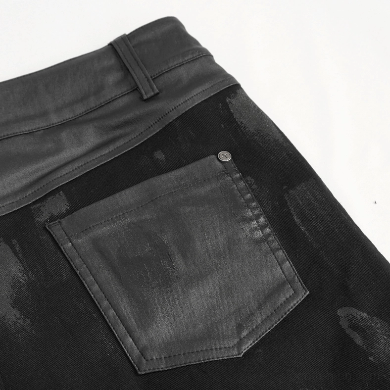 Close-up detail of black gothic cargo pants leather patchwork pocket with faded coated fabric texture