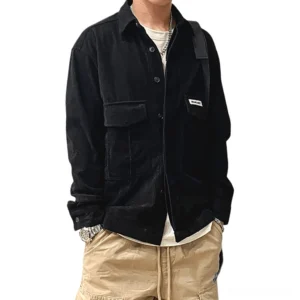 Black oversized gothic cargo shirt with dual large pockets, worn by male model in studio setting, showcasing front view with flap pocket detailing and brand patch