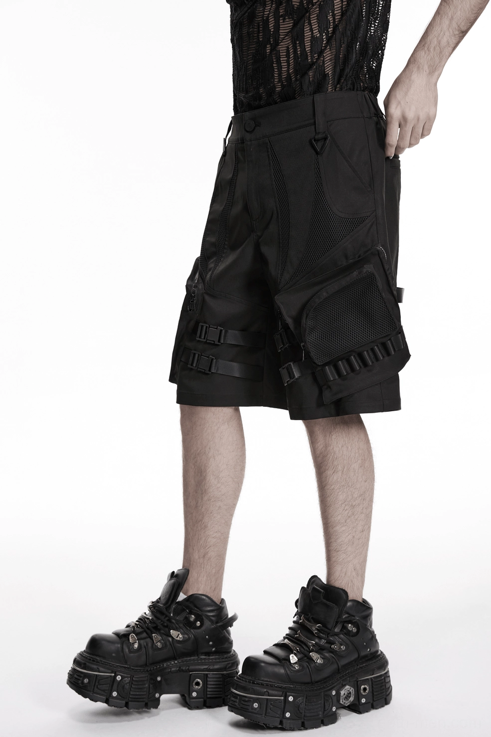Side angle view of man wearing black gothic cargo shorts with reinforced seams and techwear aesthetic