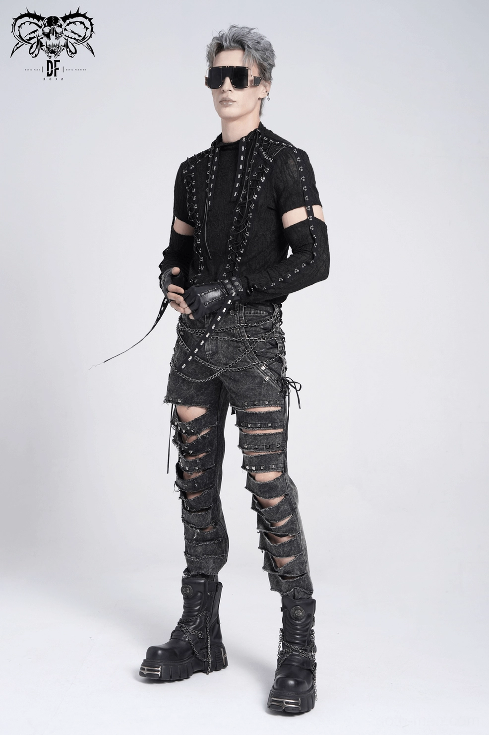 Black distressed gothic jeans full composition view, extreme leg slashes with metal chain harness system and industrial lace details