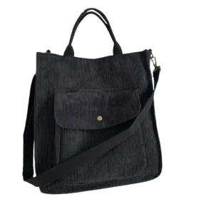 Black gothic corduroy tote bag with snap pocket and detachable crossbody strap, flat lay front view on white background