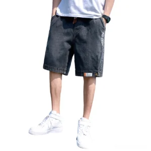 Black gothic loose denim shorts for men with embossed letter prints and buttoned cuffs, front view on white background