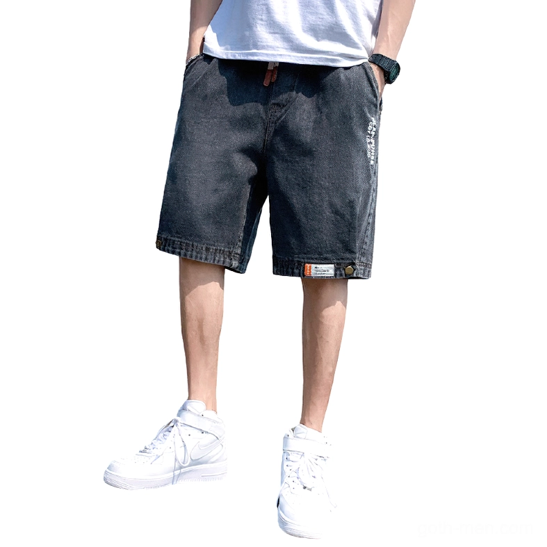 Black gothic loose denim shorts for men with embossed letter prints and buttoned cuffs, front view on white background
