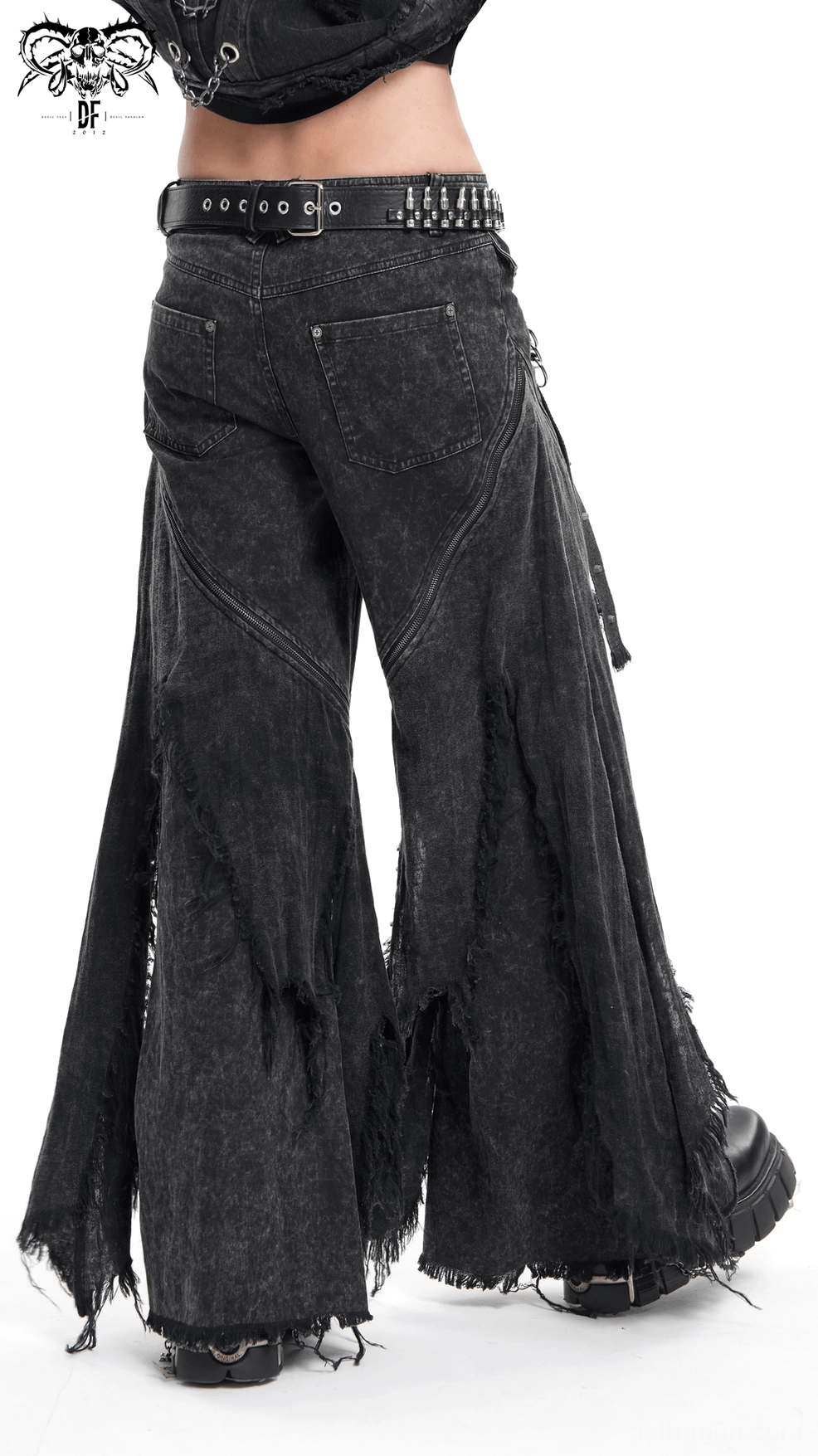 Close-up texture shot of black washed denim with strategic distressing and frayed panel details