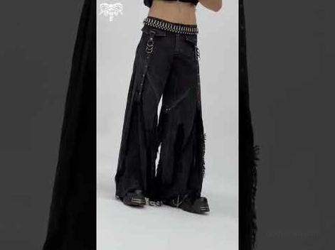 Side profile of gothic distressed jeans showing wide-leg flare and frayed denim texture on model