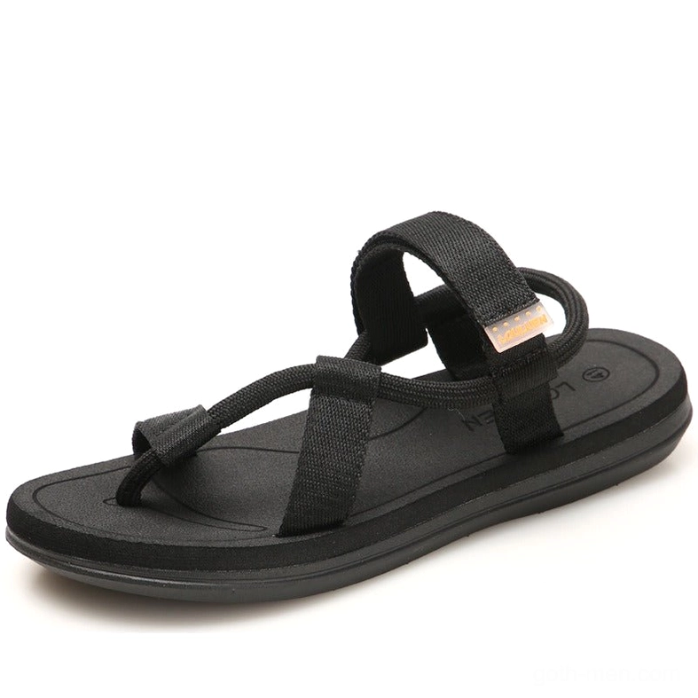 Black gothic gladiator sandals with thong strap and ankle webbing, top three-quarter view on white background
