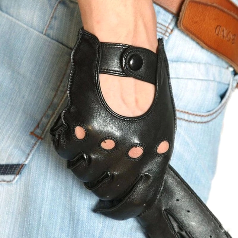 Close-up side view of black goatskin leather biker gloves worn on male hand with blue denim, showing ventilation design and wrist strap