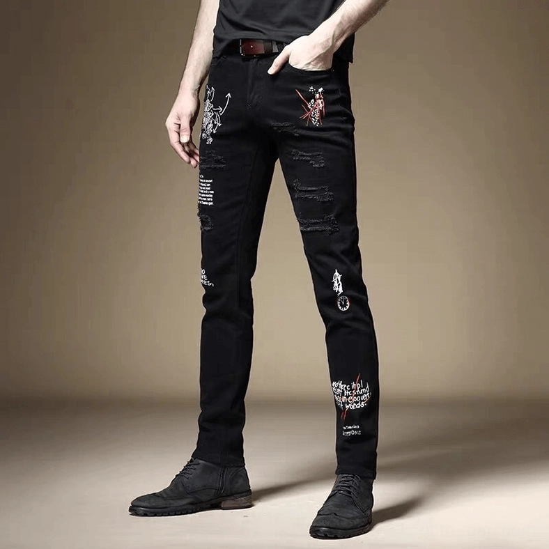 Black gothic slim ripped jeans front view showing graffiti prints and skinny fit silhouette