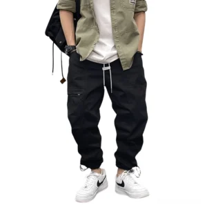 Black gothic harem cargo pants with drawstring waist worn by male model, front full-body view showcasing relaxed fit and ankle drawstring cuffs