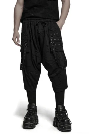 Black gothic harem pants with eyelet d-ring straps worn by male model, front view